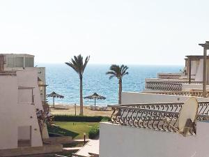 拉斯苏德尔Concorde Royal Beach Village, Ras Sidr, South Sinai Villa 116的享有建筑和棕榈树大海的景色