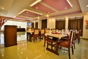 PallipuramHarbour Hotels的餐厅内带桌椅的用餐室