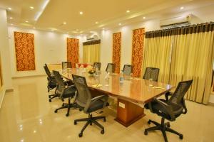 PallipuramHarbour Hotels的大型会议室,配有长桌子和椅子