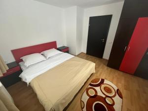 凡达提卡Pensiunea Valea Dorului的一间卧室配有一张大床和红色床头板