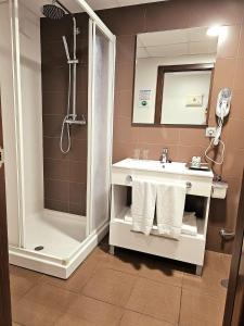 贝尼多姆Hotel Rocamar的带淋浴和毛巾水槽的浴室