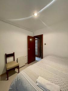 巴塞罗那3 bedrooms flat near of the beach的一间卧室配有一张床和一把椅子