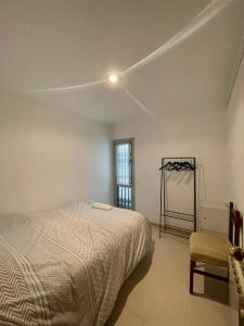 巴塞罗那3 bedrooms flat near of the beach的卧室配有床、椅子和窗户。