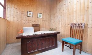 西姆拉Treebo Trend Daak Bangla Retreat With Mountain View的客房设有一张带笔记本电脑和两把椅子的书桌
