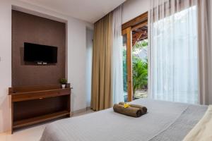 TimuranPendopo Perwitasari的一间卧室设有一张床、一台电视和一个窗口。