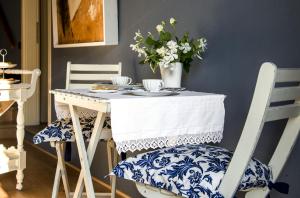 比恩帝纳Il Giardino di Ortensia B&B的蓝白桌子,椅子,盘子和杯子