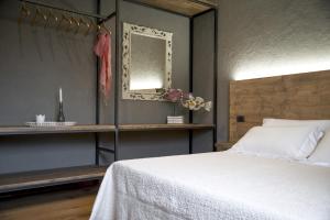 比恩帝纳Il Giardino di Ortensia B&B的卧室配有白色的床和镜子