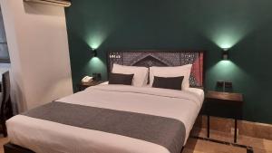 木尔坦LOKAL Rooms x Multan (City Center)的一间卧室设有一张大床和绿色的墙壁