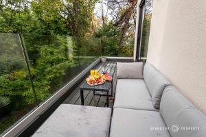 ParkstoneNEW Elegant apartment, 2 bed, balcony, Poole - Aurora's Abode的阳台配有沙发和带果盘的桌子。