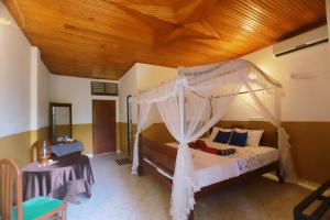 锡吉里亚The Green Heaven Resort的一间卧室设有一张带木制天花板的天蓬床。