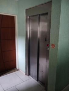 曼加拉蒂巴Apartamento Mangaratiba 2 suites的一座有门的建筑中的金属电梯
