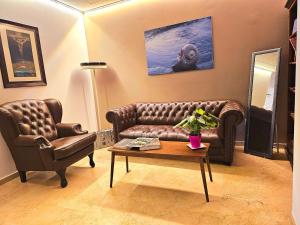 贝尼多姆Hotel Rocamar的客厅配有真皮沙发和桌子