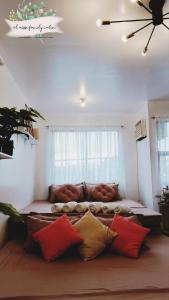 Santa RosaEl Nissi Cozy Cabins (Condo Staycation Beside the Enchanted Kingdom)的客厅配有沙发,房间配有枕头