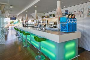 圣安东尼奥湾贝拉海滩公寓的餐厅的酒吧,带绿色凳子