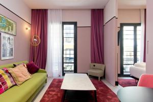 马德里Amor de Dios 17 Luxury Suites的客厅配有绿色沙发和桌子