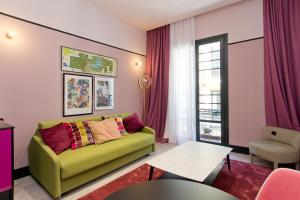 马德里Amor de Dios 17 Luxury Suites的客厅配有绿色沙发和桌子