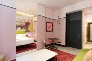马德里Amor de Dios 17 Luxury Suites的一间卧室配有一张床、一张桌子和一张桌子。