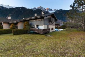 夏蒙尼-勃朗峰Chalet Ancelles - Les Praz - Golf - Vue Mont-Blanc - Randonnées的一座房子,设有一座大院子,后面有群山