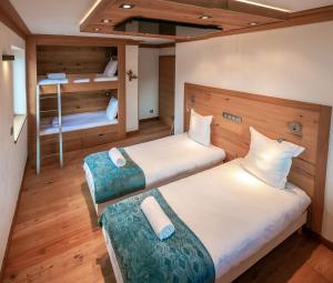 里雾诗Les Ecureuils -Rénové 100m2 - 8per - Skis aux Pieds - Vue sur la Montagne的客房设有两张床和一张双层床。