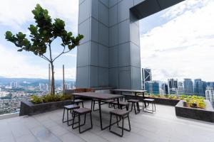 吉隆坡Royce KLCC Kuala Lumpur City Centre by Dormeo Destinations的大楼顶部的桌椅