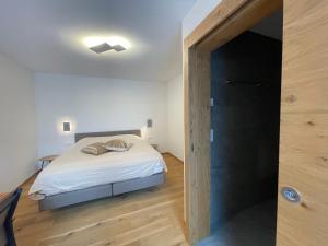萨斯费Berghof的一间卧室设有一张床,门通往走廊