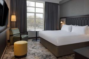卡迪夫希尔顿加的夫酒店的一间设有大床和窗户的酒店客房