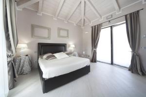 Castelletto Molina卡斯特雷托别墅酒店的白色卧室设有床和大窗户