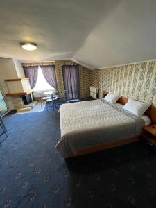 多斯帕特Хотел ПАНОРАМА ДОСПАТ的酒店客房配有一张床铺和一张桌子。