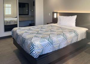 塔斯廷Motel 6 Tustin, CA Orange County的一张位于酒店客房的床铺,配有一张大床