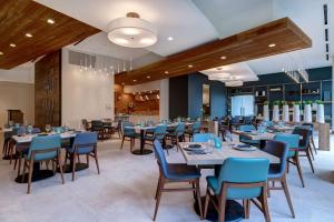 安纳海姆Hilton Garden Inn Anaheim Resort的一间配备有桌子和蓝色椅子的用餐室