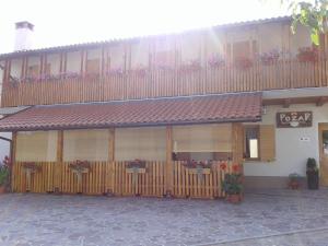 Knežak普里珀札茹农家乐的前面有栅栏和鲜花的建筑
