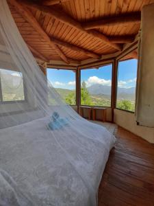 奥尔穆埃Swiss Eco Lodge La Linda Loma - Olmué的一间设有床铺的卧室,位于带窗户的房间内