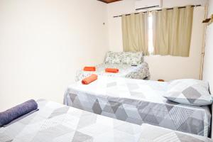 阿拉卡茹Hostel mineiros的一间设有两张床和椅子的房间