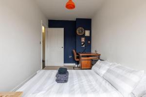 马盖特SEA HEIGHTS MARGATE的一间卧室配有一张床和一张带时钟的书桌
