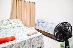 阿拉卡茹Hostel mineiros的客房设有两张床和风扇。