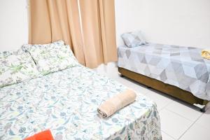 阿拉卡茹Hostel mineiros的客房设有两张床和一张带枕头的床。