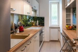 特尔纳瓦Sunny apartment in Trnava的厨房配有白色橱柜和水槽