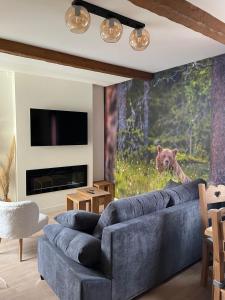 波泰皮莫朗CASTEL ISARD - Le Refuge的客厅配有蓝色的沙发和熊壁画