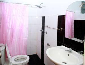 埃拉Ella Sanron guest & Ayurvedic Spa的浴室设有粉红色的淋浴帘、卫生间和水槽。