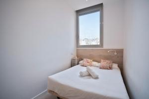 巴塞罗那BcnStop Sant Pau Suites的卧室配有白色的床和窗户