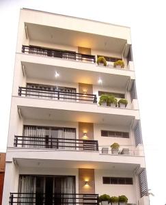 科伦坡Bliss Apartments Colombo的带阳台和盆栽植物的白色公寓大楼