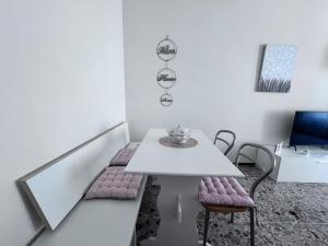 卡萨莱蒙费拉托Casa Piemont的白色的用餐室配有白色的桌椅