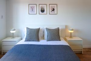 利马索尔Phaedrus Living: Ourania City Heights Flat的一间卧室配有一张蓝色的床、两张桌子和两盏灯。