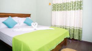 卡图纳耶克Airport Villa D 87的一间卧室配有一张带绿毯的床和窗户。