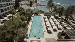 帕福斯奥尔迈拉酒店的享有带椅子的游泳池和大海的顶部景致