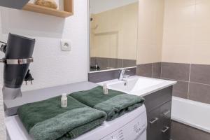 科洛米耶Le Beluga – Appartement proche Airbus的一间带水槽和绿毛巾的浴室