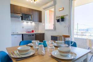 科洛米耶Le Beluga – Appartement proche Airbus的厨房配有木桌和餐具