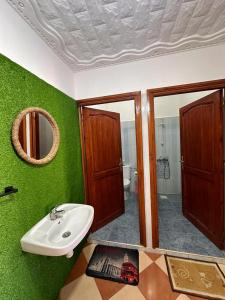 依索安Olas Surf House的绿色浴室设有水槽和镜子