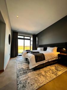 德尔斯特鲁姆Highland Gate Range View的一间卧室设有两张床和大窗户