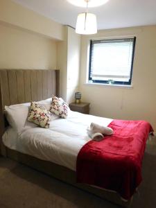 格拉斯哥Fabulous 2 bed apt 10 mins from City Centre的一间卧室配有一张带红色毯子的大床